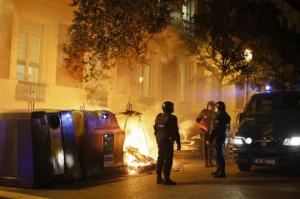 Riot police stand next to a fire set by demonstrators in Madrid, during a demonstration in support of protesters in Burgos opposing an urban project